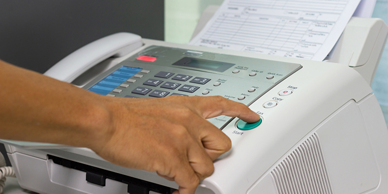 hand man are using a fax machine in the office. Business concept