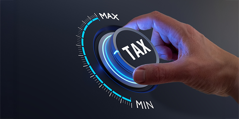 Tax reduction and deduction for businesses and individuals. Concept with hand turning knob to low taxation rate. Return form, exemptions, incentives.