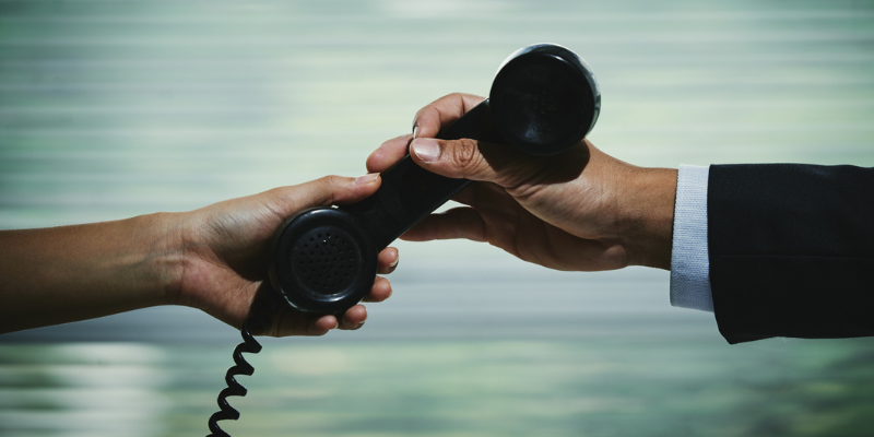 coworkers handing over a call, illustrating a legacy phone system migration